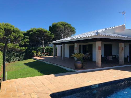 una casa con piscina frente a ella en Villa con piscina Cala Morell, en Cala Morell