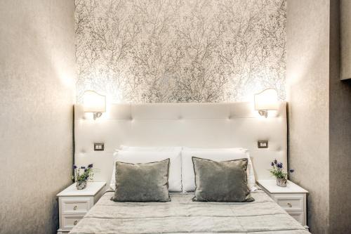 a bedroom with a large white bed with two pillows at Santamaria Inn in Rome