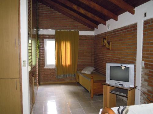 uma sala de estar com televisão e uma parede de tijolos em Cabañas Moconá em Dos de Mayo