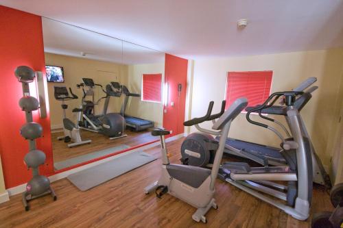 a gym with three exercise bikes and a mirror at Ramada London North in Barnet