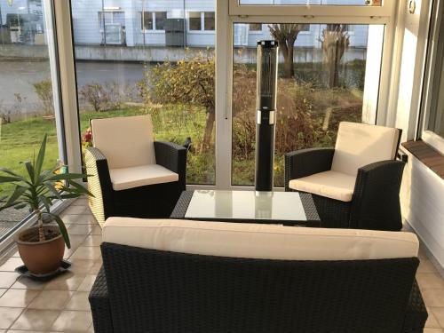 een veranda met 2 stoelen, een tafel en een raam bij Maxbed in Flensburg