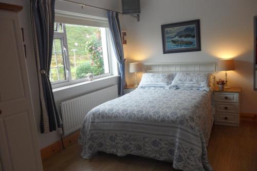 1 dormitorio con cama y ventana en Rockmount House B&B, en Clifden