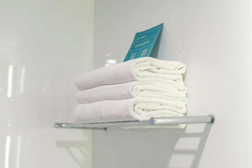 - une pile de serviettes sur un porte-serviettes dans la salle de bains dans l'établissement Libre Hotel, BW Signature Collection by Best Western, à Lima