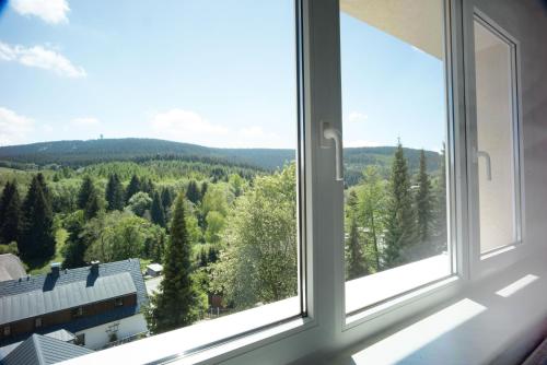 an open window with a view of the forest at Oberwiesenthal Apartments in Kurort Oberwiesenthal