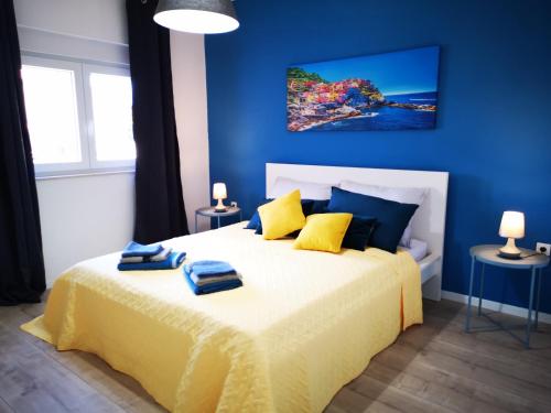 niebieska sypialnia z dużym łóżkiem z żółtą pościelą w obiekcie Apartment Sunrise, coastal Istra, Pula Duga Uvala Pavićini w mieście Pavicini