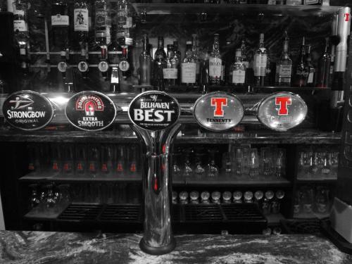 a bar with a bunch of bottles of alcohol at Macbeth Arms in Lumphanan