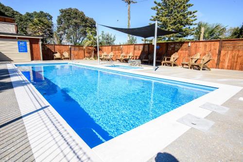 a swimming pool with blue water in a backyard at Tasman Holiday Parks - Ohiwa in Opotiki