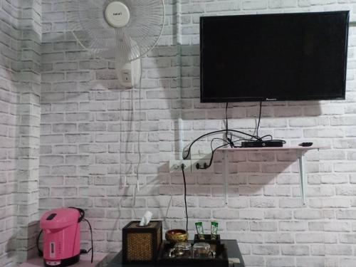 a white brick wall with a flat screen tv at เซราะกราว บูติก รีสอร์ท Sohground Boutique Resort in Prakhon Chai