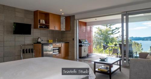 a room with a kitchen and a living room at Bay Of Islands Beachhouses in Paihia