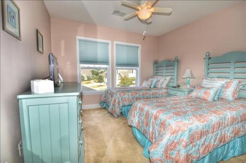 a bedroom with two beds and a ceiling fan at 612 Egret Run Cabin in North Myrtle Beach