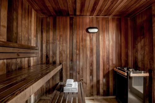 努沙岬的住宿－努薩法語區曼特拉酒店，一间设有木墙的桑拿浴室和一个室内长凳