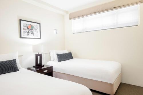 a bedroom with two beds and a window at Mantra French Quarter Noosa in Noosa Heads