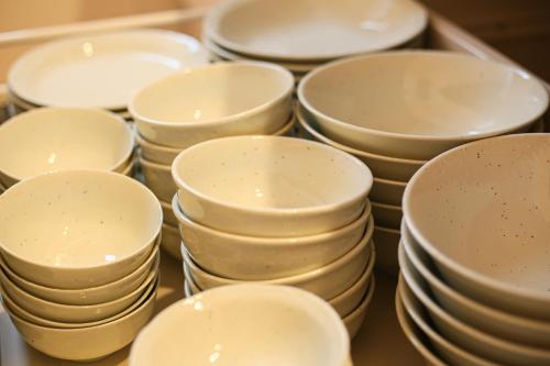 a pile of white plates sitting on a table at #オーシャンビューBBQ可能 #4LDK新築一軒家 #長期滞在歓迎 -- 時空間 凪 Nagi -- in Hyakuna
