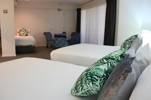 a hotel room with two beds with green and white sheets at The Lord Forrest Hotel in Bunbury