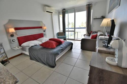 a bedroom with a large bed with red pillows at Studio vue mer Le Gosier sans coupure d'eau in Le Gosier