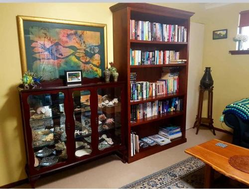 a living room with two book shelves filled with books at Layton Street Apartments in Esperance