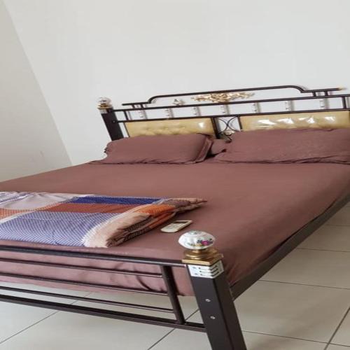 cama con marco metálico y sábanas púrpuras en Mediterania Garden Residence 2, en Yakarta