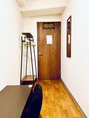 a room with a door and a shelf and a table at Hostel Furoya in Osaka
