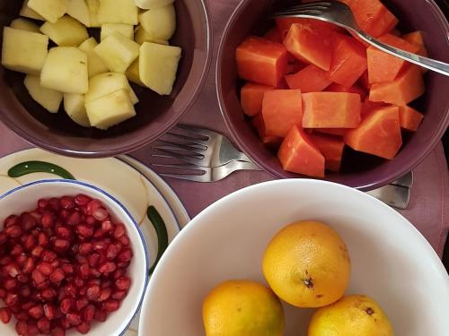 uma mesa com uma fruteira e uma tigela de romãs em Atulya Kanchi Camp Bandhavgarh em Tāla
