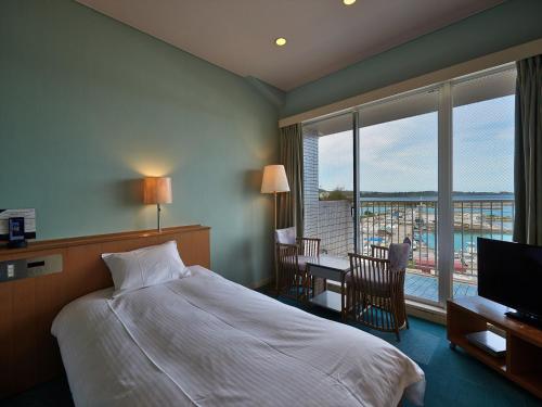 a hotel room with a bed and a balcony at Ocean Resort PMC in Onna