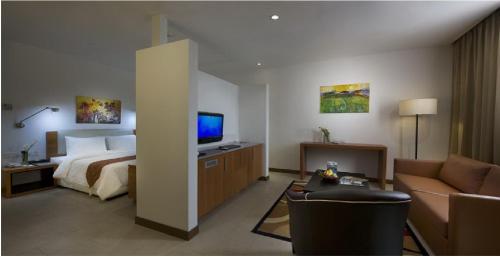 a hotel room with a bed and a television at Gloria Swiss Hotel & Apartment Sandakan in Sandakan
