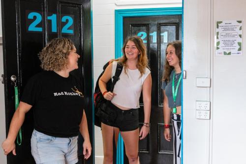 a group of three women standing in front of a door at Mad Monkey Central in Cairns