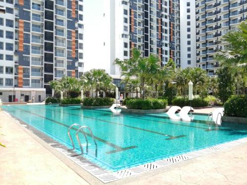 a swimming pool with swans and buildings in the background at Timurbay STUDIO APARTMENT - Seaview and Poolview by Dbayu - MU5LIM ONLY - Free WIFI in Kuantan