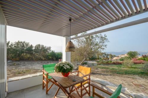 a patio with a table and chairs and a view of the ocean at Ydreos Studios & Apartments in Mikri Vigla