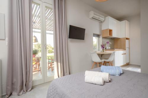 a bedroom with a bed and a kitchen with a balcony at Ydreos Studios & Apartments in Mikri Vigla