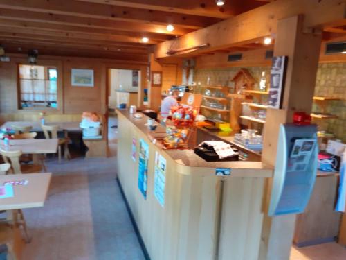 uma cozinha com um balcão e uma pessoa num restaurante em B&B Pension Lärch em Obergesteln