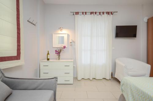 a bedroom with a bed and a dresser with a mirror at Ydreos Studios & Apartments in Mikri Vigla