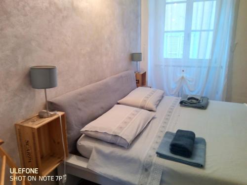 a small bedroom with a bed with towels and a lamp at A Casa di Irene in Como