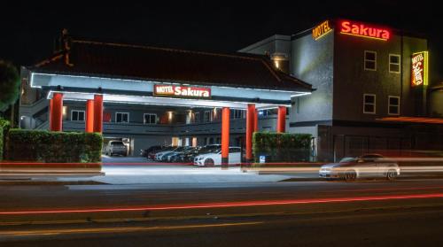 a hotel with cars parked in a parking lot at night at Sakura Inn in Glendale