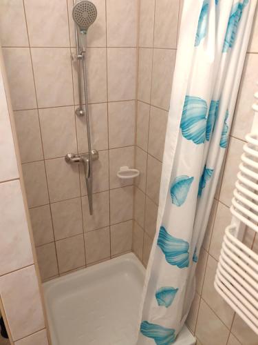 a shower with a shower curtain in a bathroom at Willa Zacisze Sianożęty in Sianozety