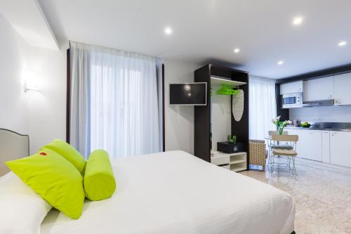 sypialnia z dużym białym łóżkiem z żółtymi poduszkami w obiekcie Sorrento Flats w Sorrento