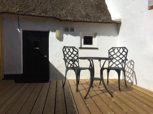 een tafel en twee stoelen voor een huis bij Bakers Cottage Ludham - Norfolk Broads in Ludham