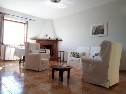 a living room with white furniture and a table at Villa Raniero Gatti in San Michele in Teverina