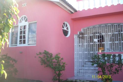 a pink house with a gate and a window at Tina's Guest House in Ocho Rios