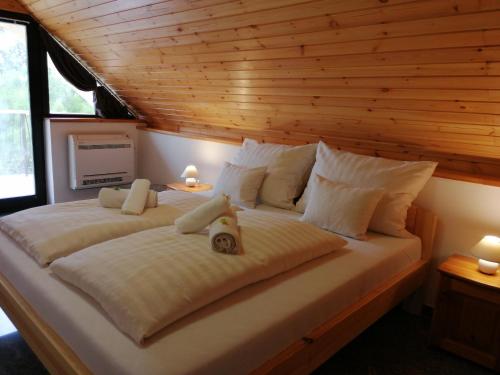 a large bed in a room with a wooden ceiling at Casa Ninfea Panzió in Cserszegtomaj