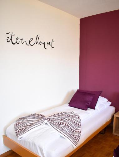 a bed in a room with a sign on the wall at Hostellerie d'Orzival in Vercorin