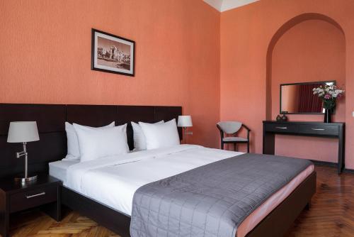 
a hotel room with a large bed and two lamps at Tsentralnaya Hotel in Odesa
