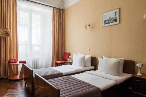 a hotel room with two beds and a window at Tsentralnaya Hotel in Odesa