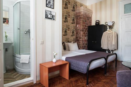 a bedroom with a bed and a bathroom with a tub at Tsentralnaya Hotel in Odesa