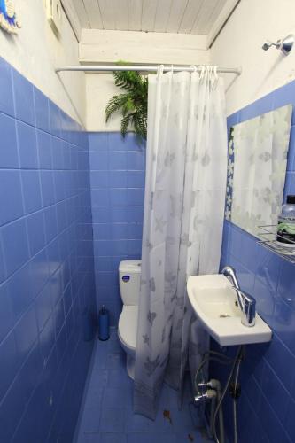 a blue tiled bathroom with a toilet and a sink at Smiling house & Baltic beach in Jūrmala