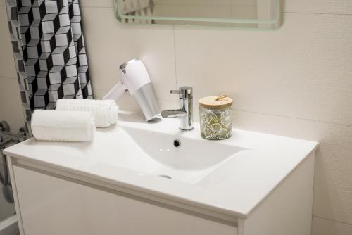 a bathroom sink with a roll of toilet paper on it at Family apartments Albur Village II in Alvor