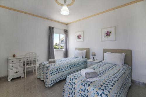 a bedroom with two beds with blue and white sheets at Villa Santo Estevão in Olhos de Água