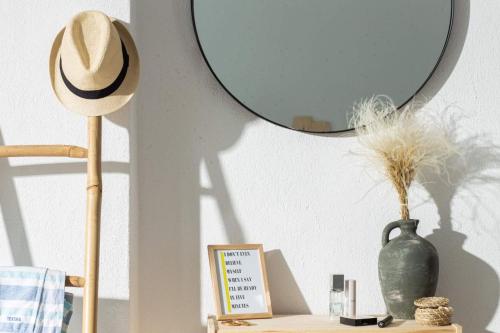 a mirror on top of a table with a vase at Villa Ble in Nea Vrasna