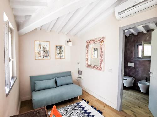 sala de estar con sofá azul y espejo en La Bacaia, en Marciano Della Chiana