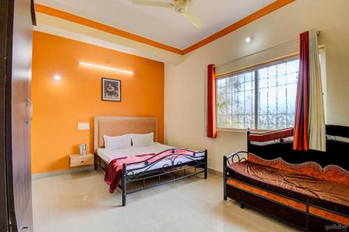 1 dormitorio con 2 camas y ventana en Shilpa Strawberry Garden, en Mahabaleshwar