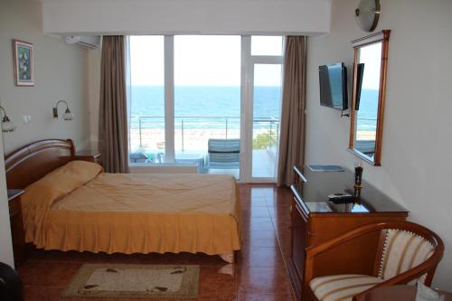 a bedroom with a bed and a balcony with the ocean at Hotel Comandor in Mamaia